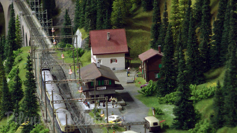 Trenes en miniatura de Suiza cruzando el puente del ferrocarril en el ancho de vía métrico