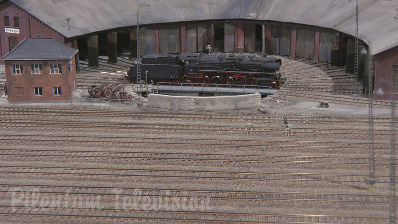 Locomotive à vapeur et trains miniatures sur une maquette ferroviaire en échelle HO